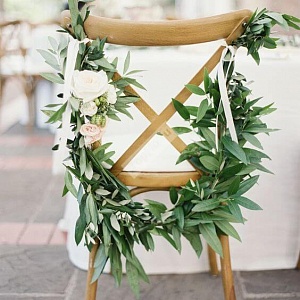 Украшение стула листьями и белыми цветами