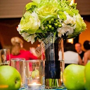 Цветочная композиция на стол гостей из зеленого букета и зеленых яблок