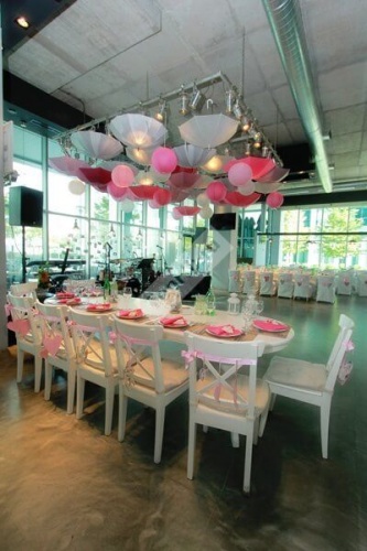 Украшение зала свадьбы в розовом цвете с подвешенными зонтиками