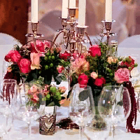 Цветочная композиция на стол гостей с розой в ярко розовых тонах