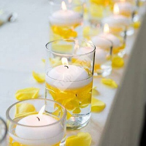Украшение стола свечами и жёлтыми лепестками