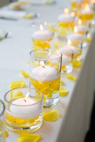 Украшение стола свечами и жёлтыми лепестками