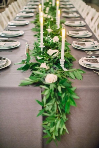 Украшение стола листьями и белыми свечами