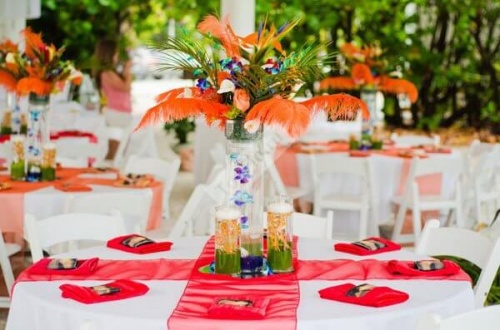 Украшение свадебных столов в оранжевом цвете с перьями