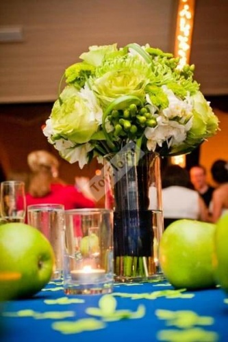 Цветочная композиция на стол гостей из зеленого букета и зеленых яблок