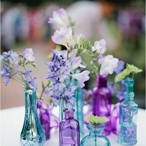 Цветы на столы гостей в разноцветных бутылочках