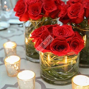 Цветочная композиция на стол гостей из красных роз со свечами