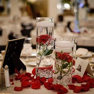 Цветочная композиция на стол гостей с красными розами и лепестками