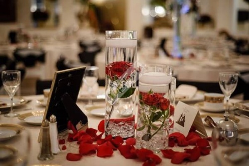 Цветочная композиция на стол гостей с красными розами и лепестками