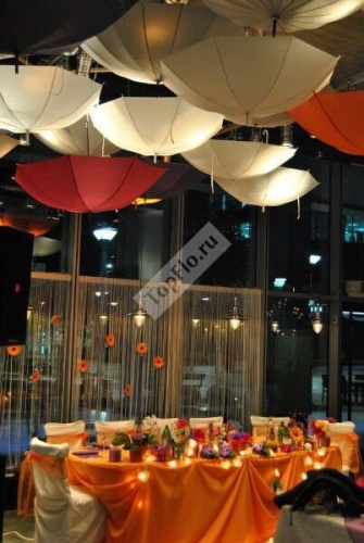 Оформление зала в оранжевом цвете с подвешенными зонтиками